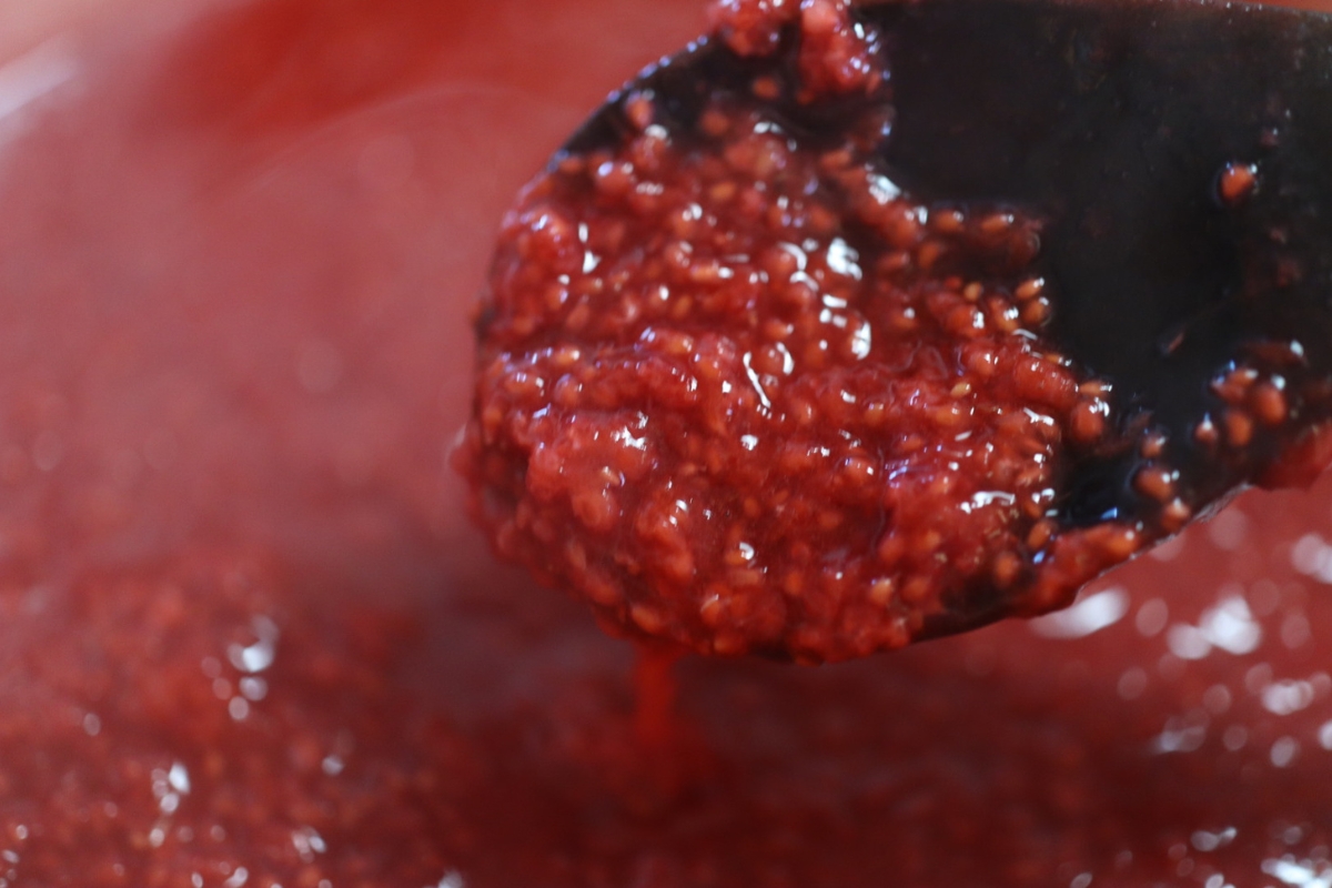 raspberry jam being stirred while cooking