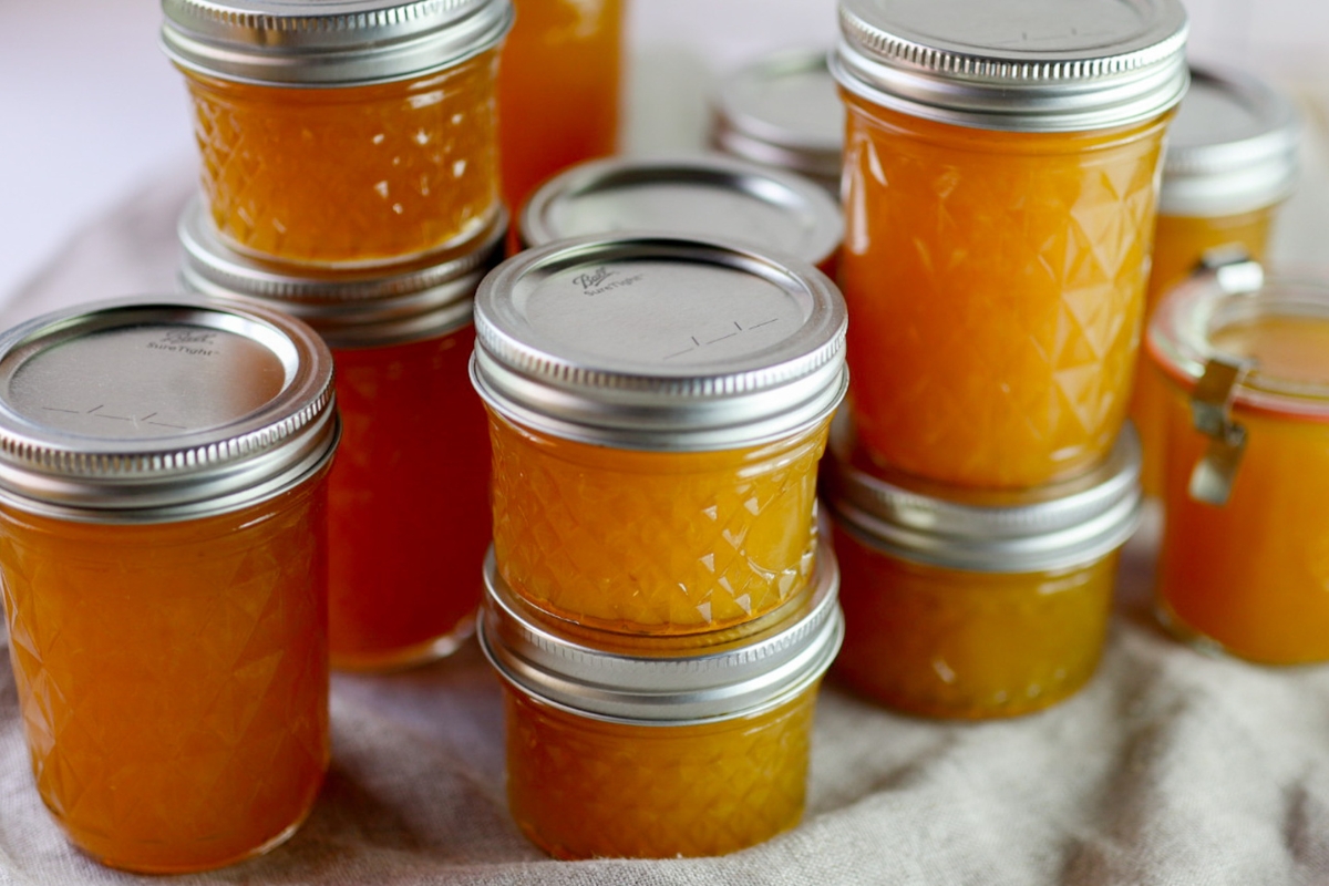 glass jelly jars full of peach marmalade