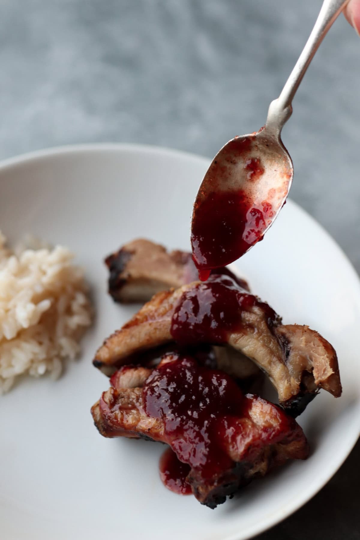plum catsup being spooned onto meat