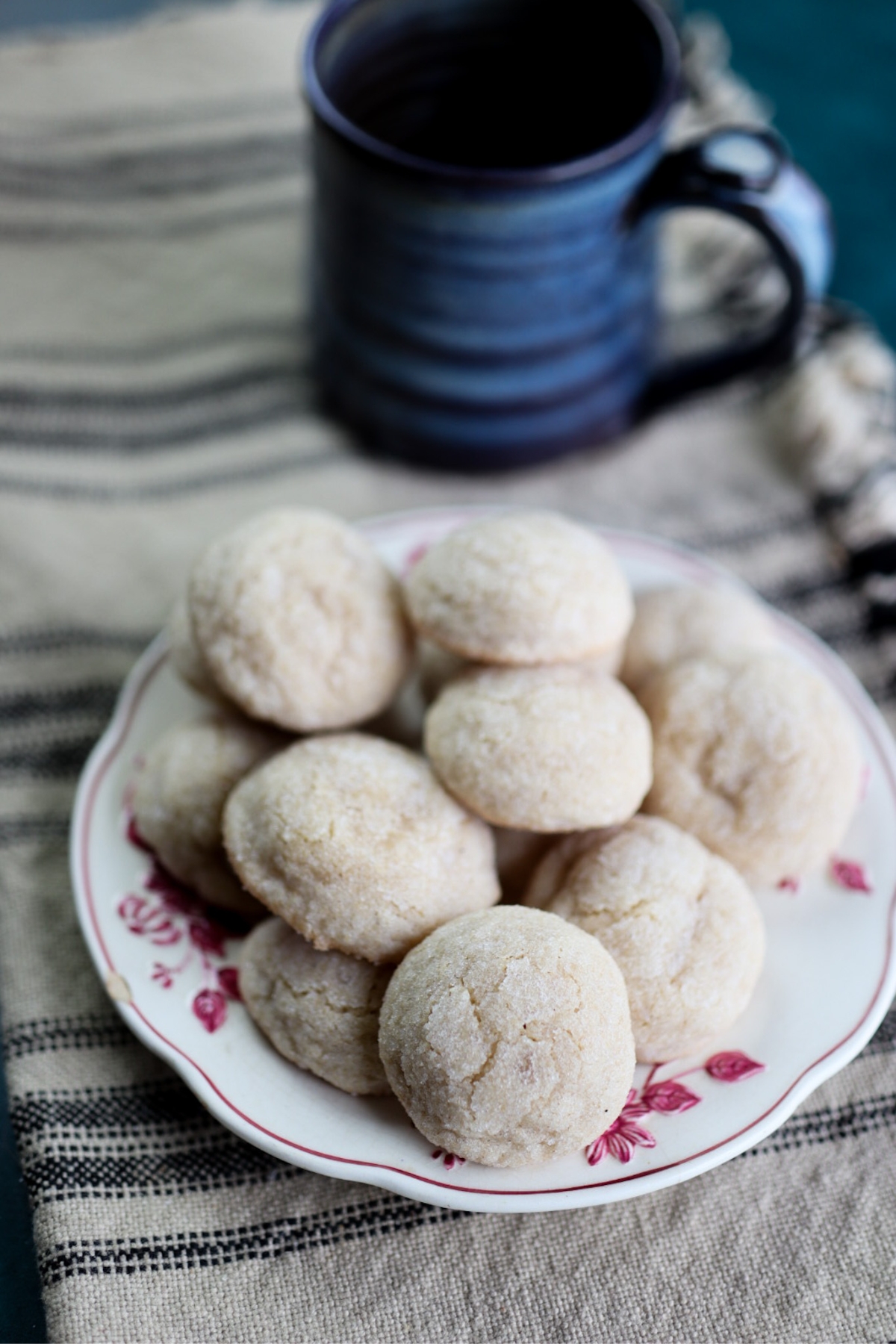 a plate of 1800's cookies next to a cup of coffee.