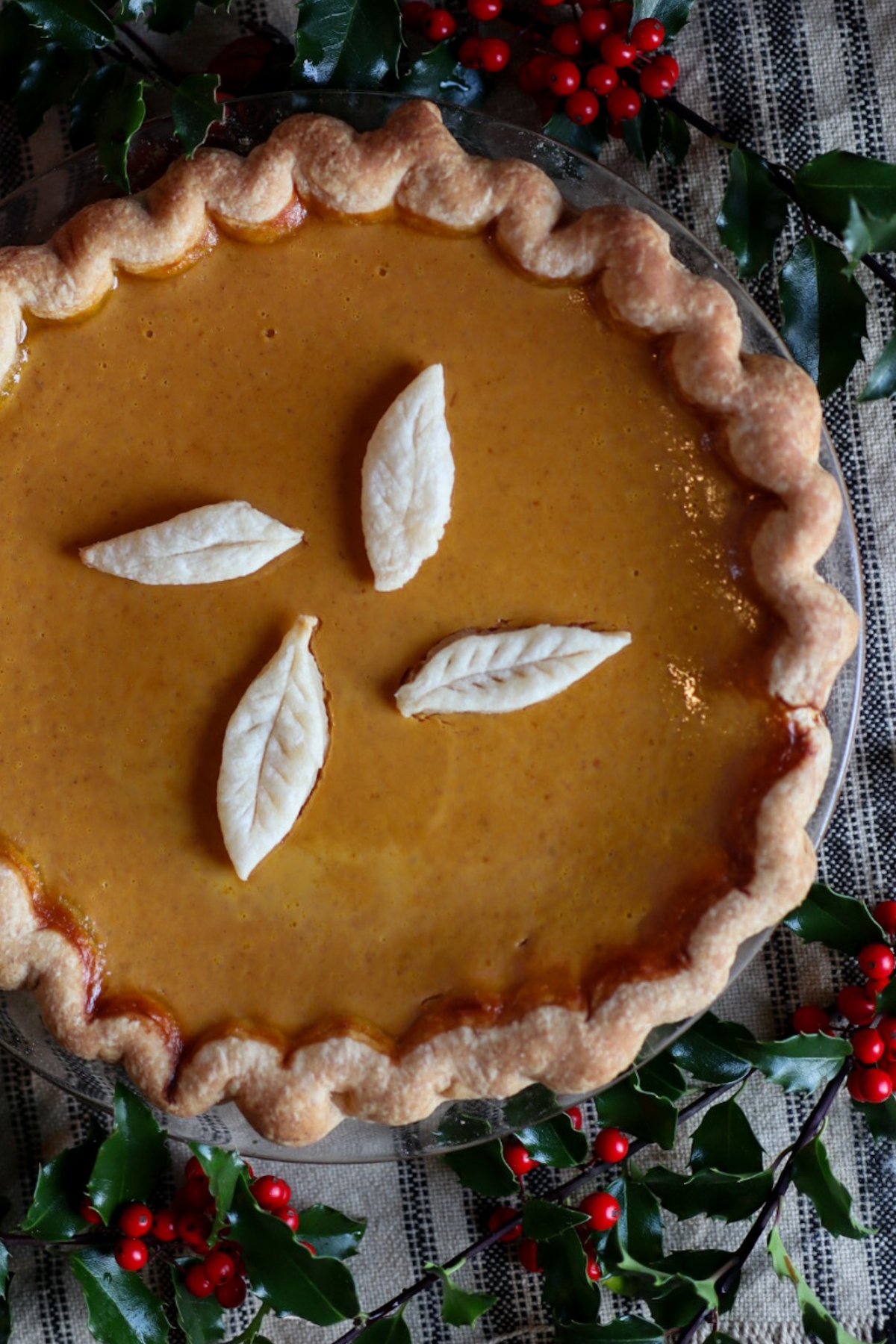 a pumpkin pie surrounded by holly