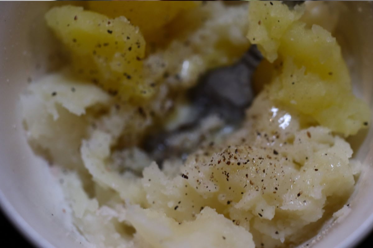 mashed potatoes being mixed in a bowl