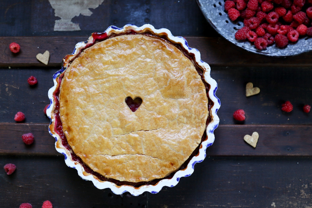 raspberry tart with cream, next to fresh raspberries
