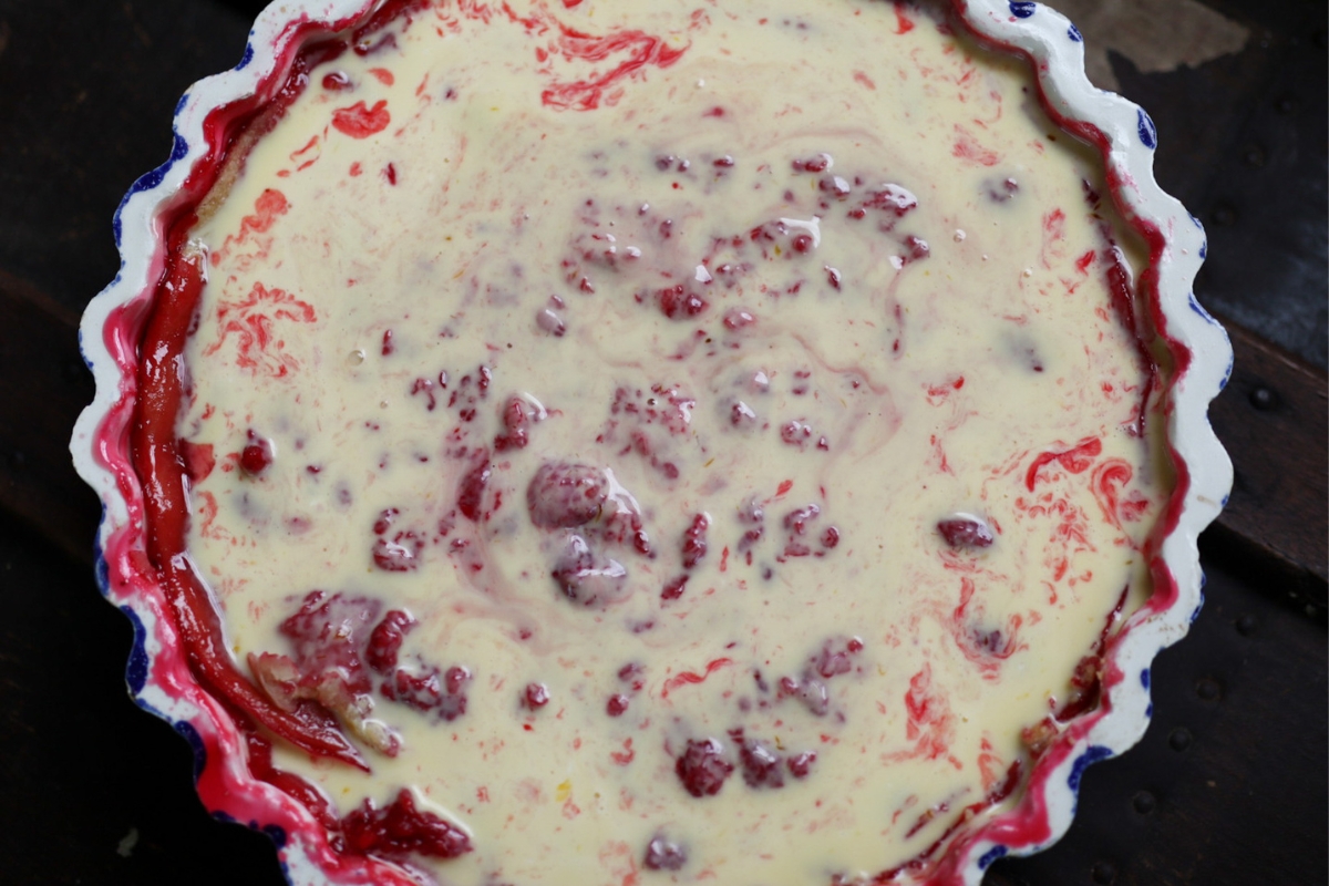 an unbaked raspberry tart with cream