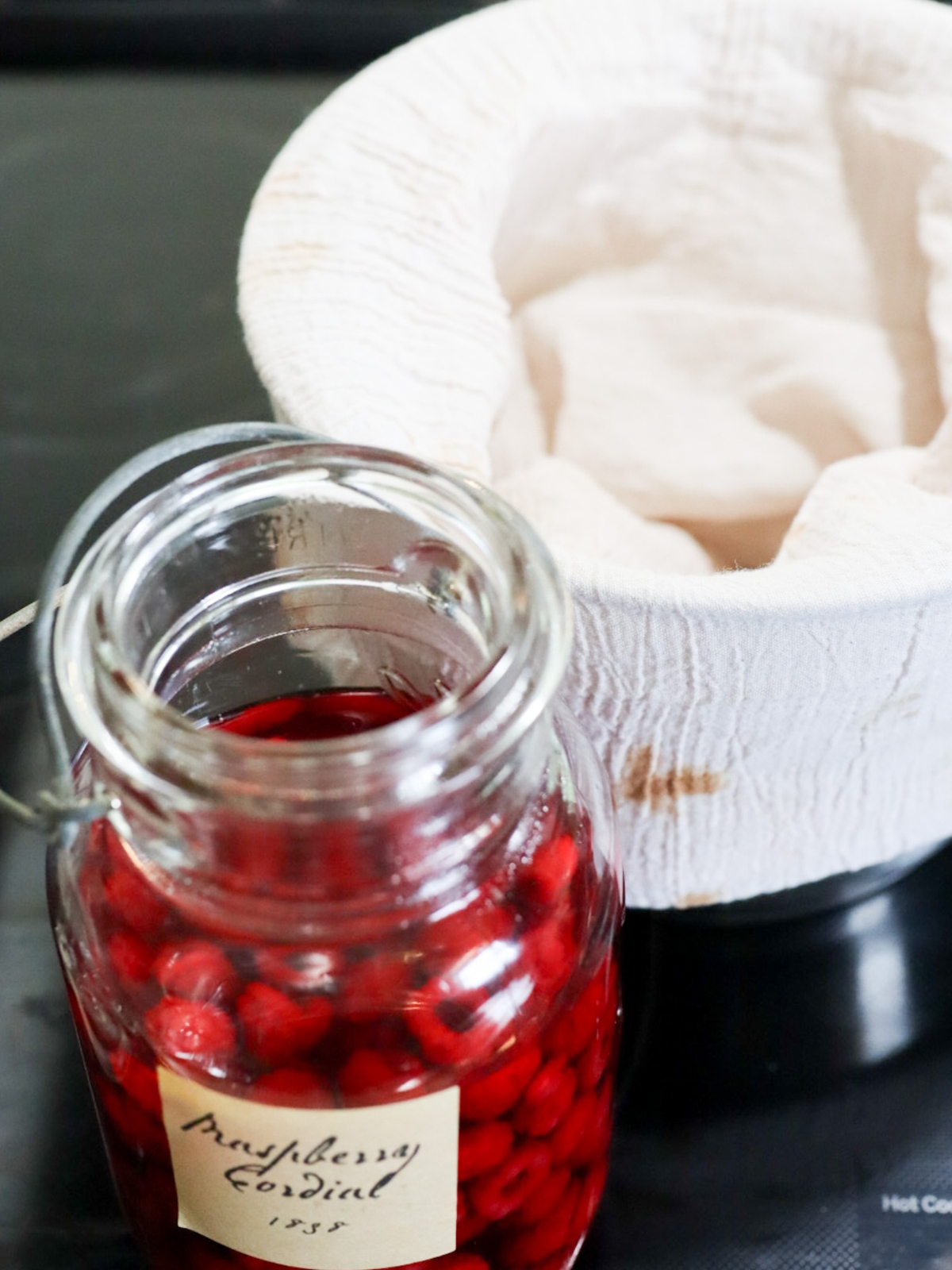 straining a jar of 1800s raspberry cordial