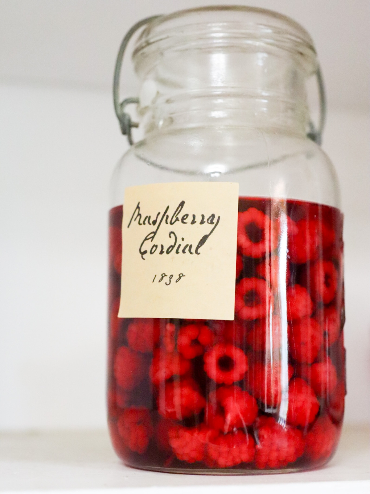 a jar of 1800s raspberry cordial being made
