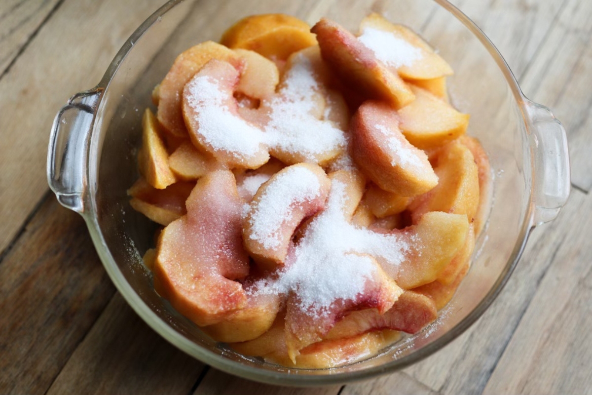 a dish of sliced peaches sprinkled with sugar